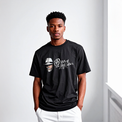 Male model wearing a black 100% cotton Beard and Hat Actor t-shirt featuring the original logo printed in full color, paired with white pants in a minimal studio setting
